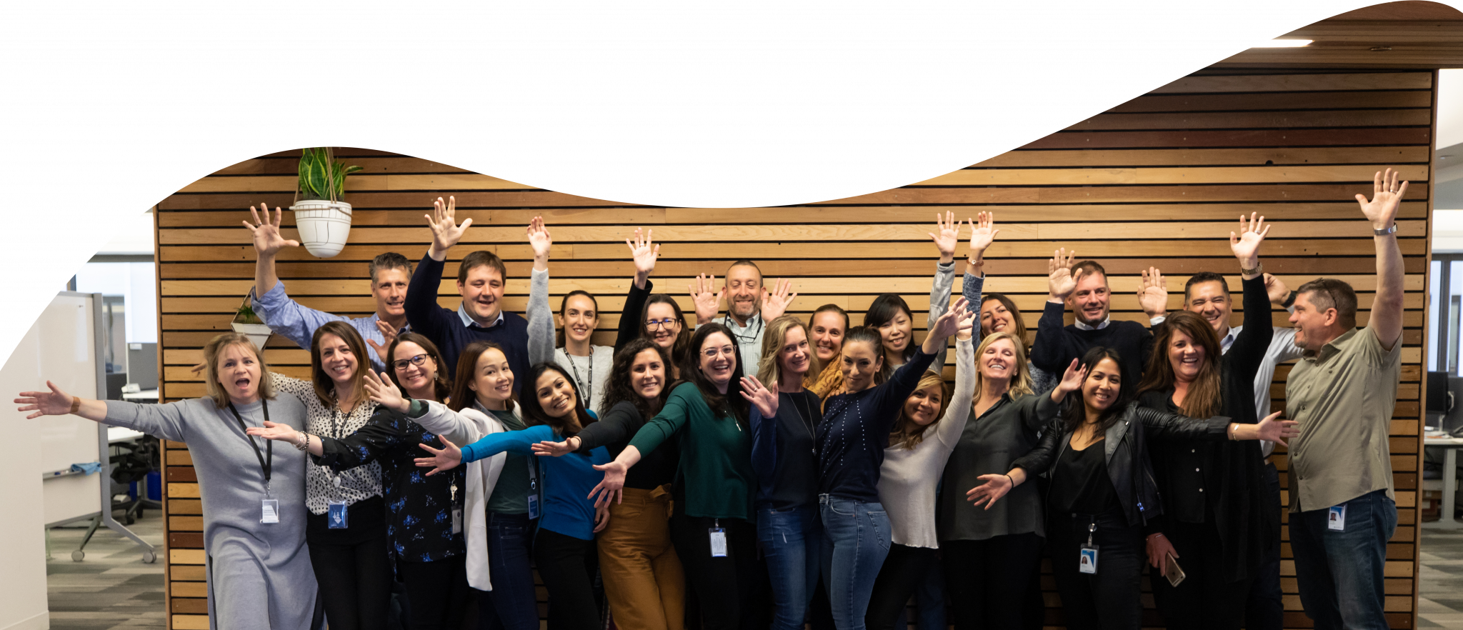 Group of employees standing together with their arms in the air